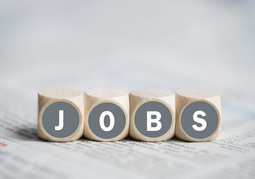 Würfel mit Aufschrift JOBS auf einer Tageszeitung