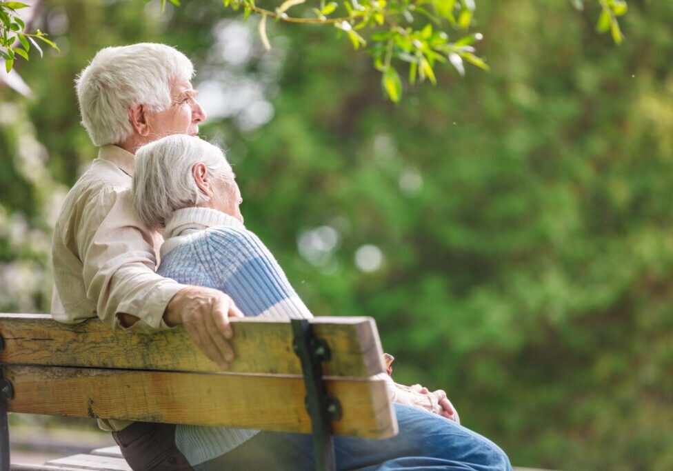 Elderly couple resting on a bench in the park