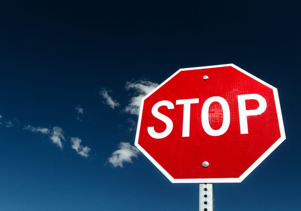 Stop sign against bright blue sky.