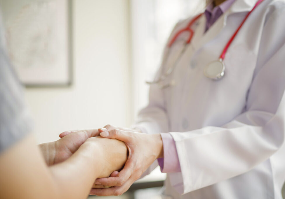 doctor comforting and hold patient hand in hospital, medical concept