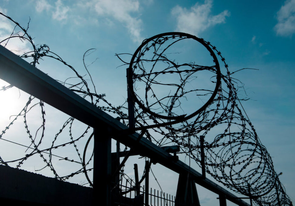 Metal barbed wire on a blue sky with white clouds. close-up