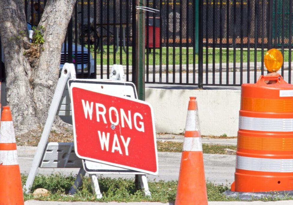 Orange traffic cones and Wrong Way Sign,Red background with white letters