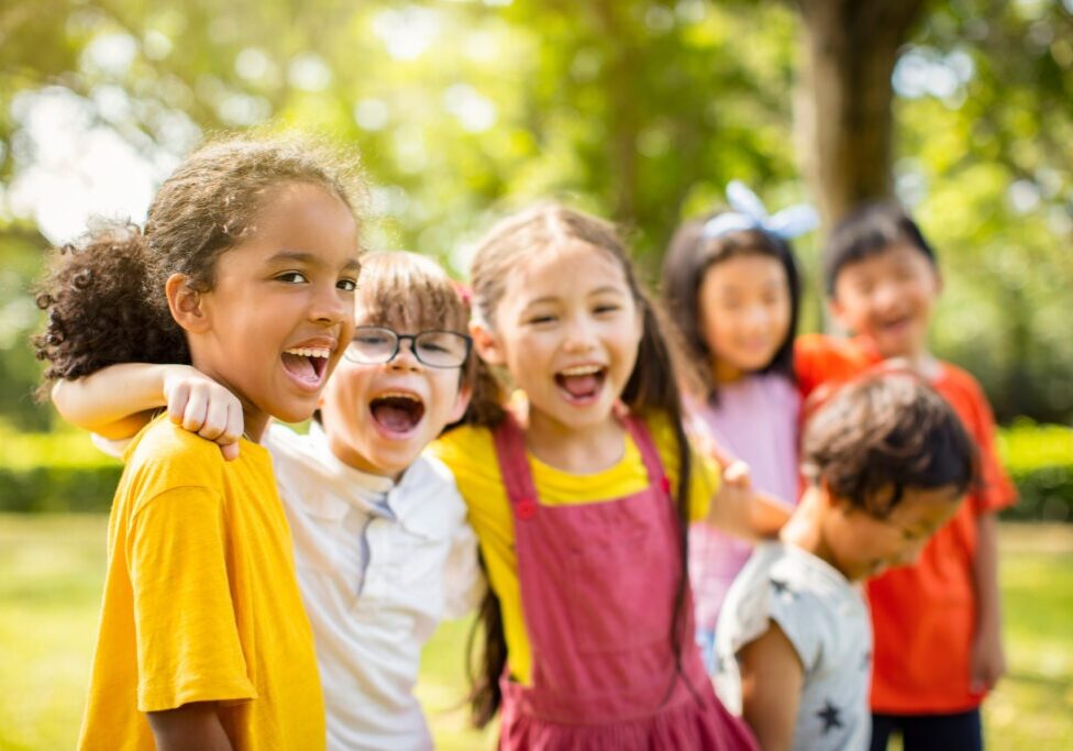 Multi-ethnic group of school children laughing and embracing