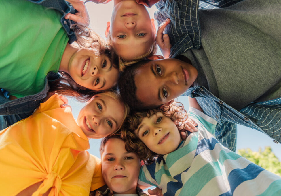 bottom view of happy multicultural kids looking at camera