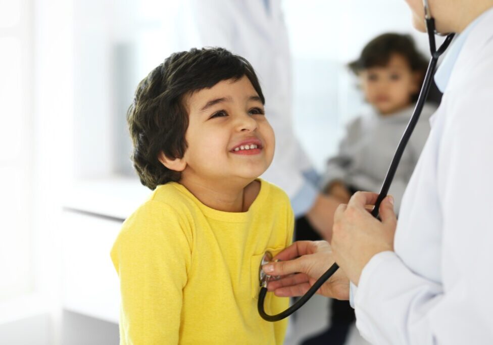Doctor examining a child patient by stethoscope. Cute baby girl at physician appointment. Medicine concept.