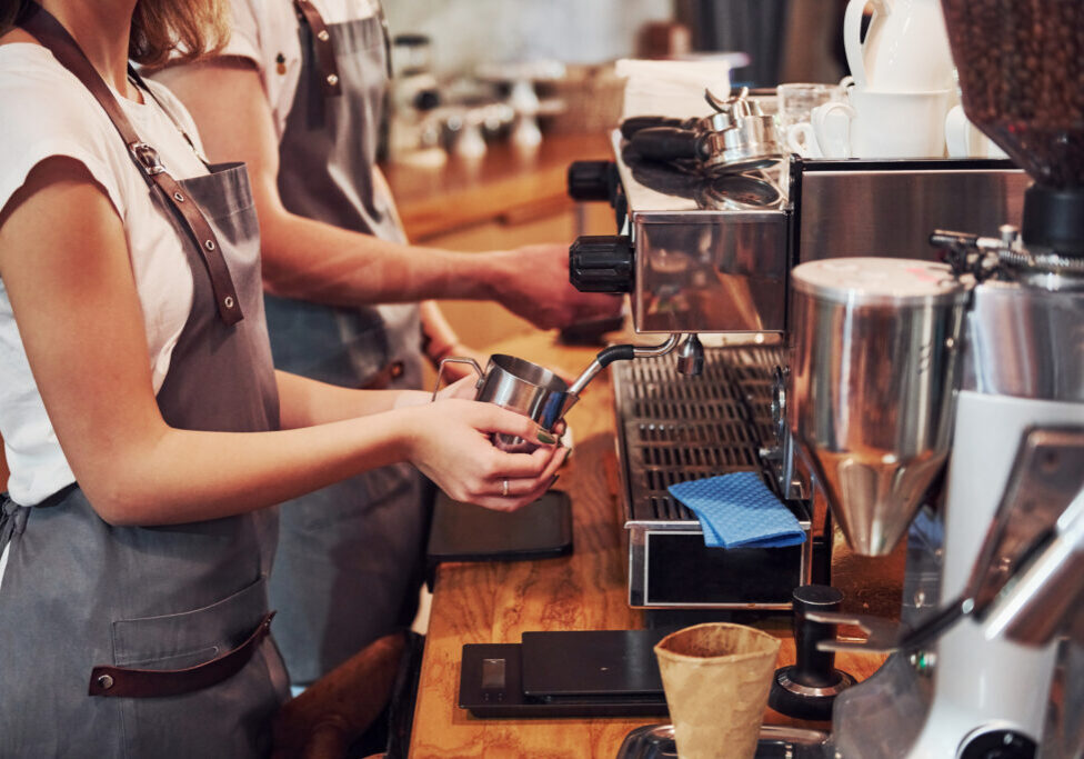 Two young cafe workers indoors. Conception of business and service.