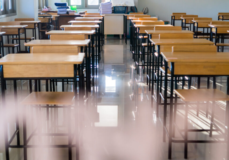 Situation of Covid-19 disease outbreak resulted in inability organize teaching learning in college. Lecture school empty classroom with desks chair iron wood when student close stay home in highschool