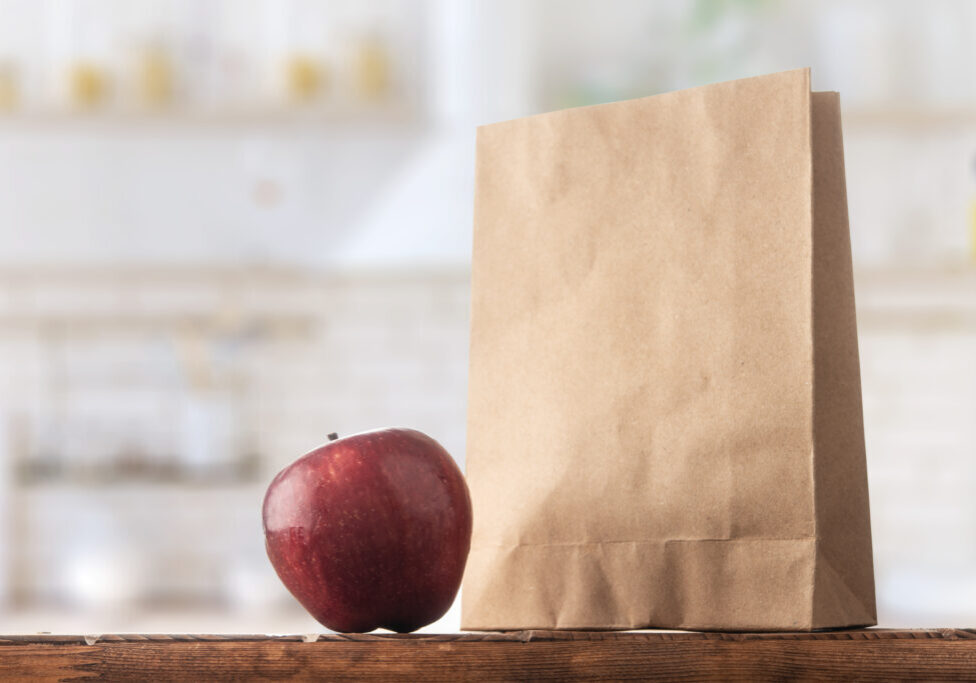 Paper bag and apple on the kitchen table