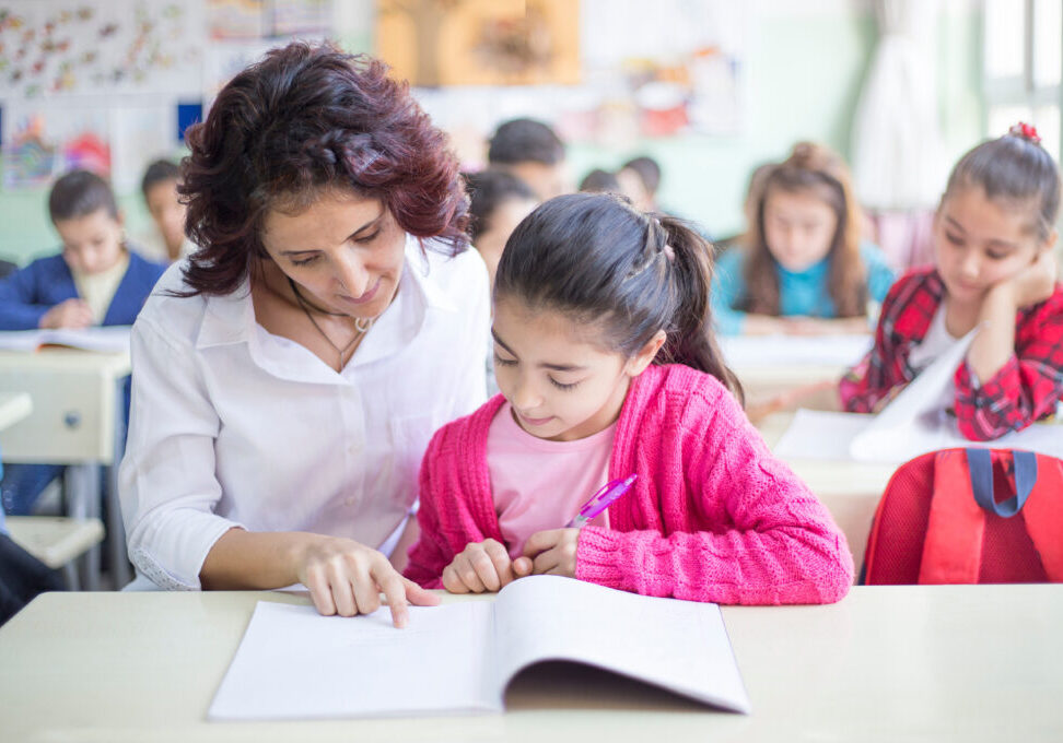 elementary schoolgirl and teacher in classroom