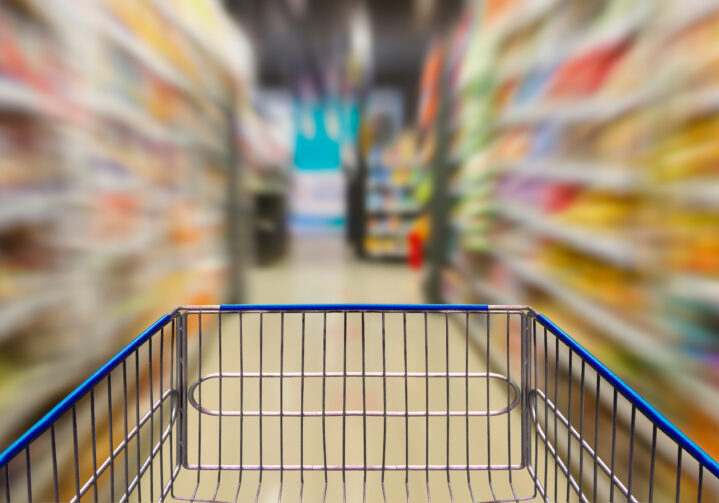 Supermarket corridor with empty blue shopping cart