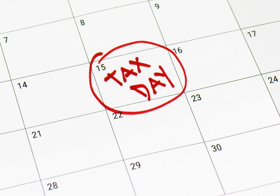 Tax day marked on April 15 calendar with red marker. Deadline for 1040 form return.