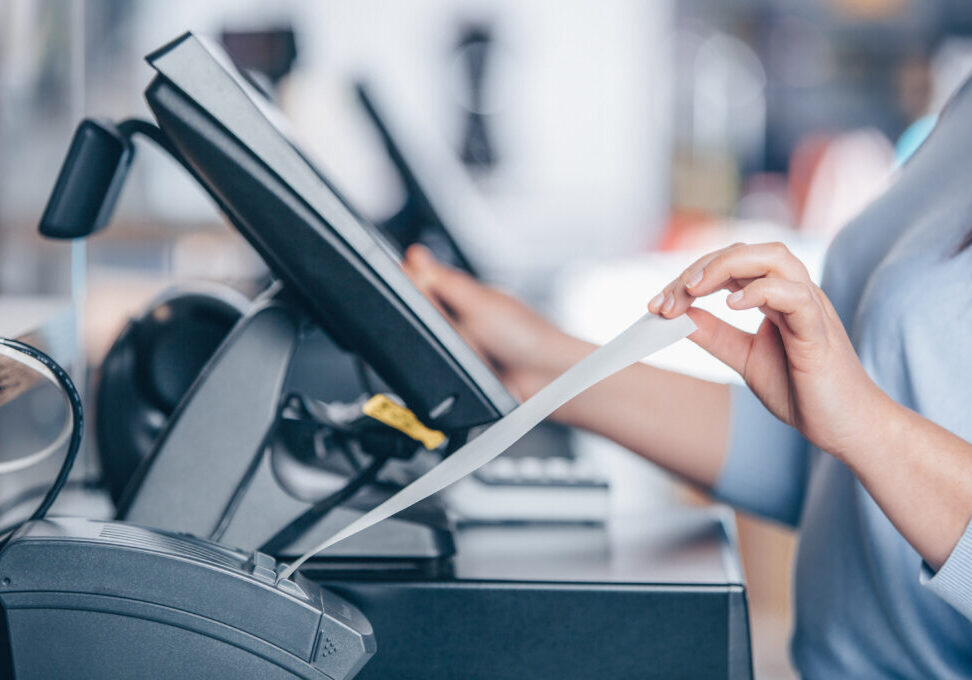 Saleswoman printing invoice or receipt for customer in the shopping center, POS system