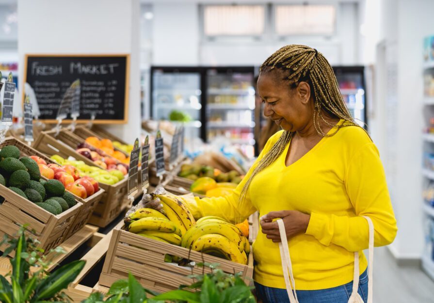 Senior African woman buying fresh fruits in supermarket