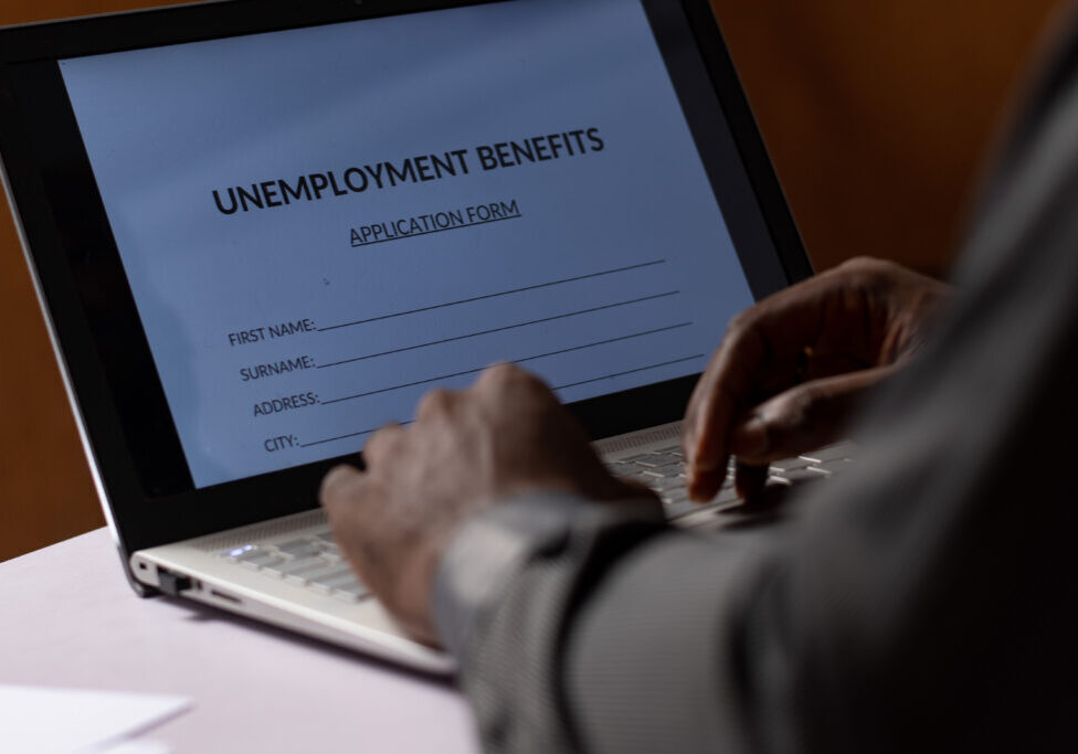 black person filling unemployment benefit form on a computer