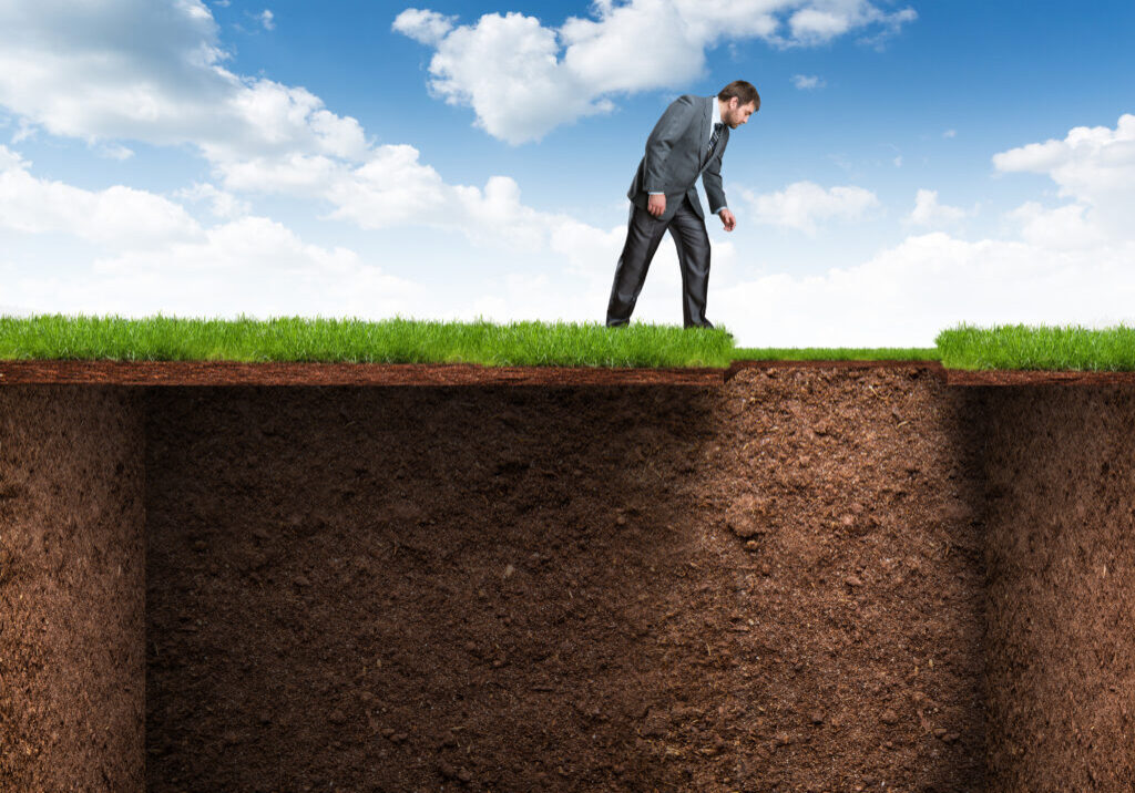 Businessman bends and looks at the empty room underground